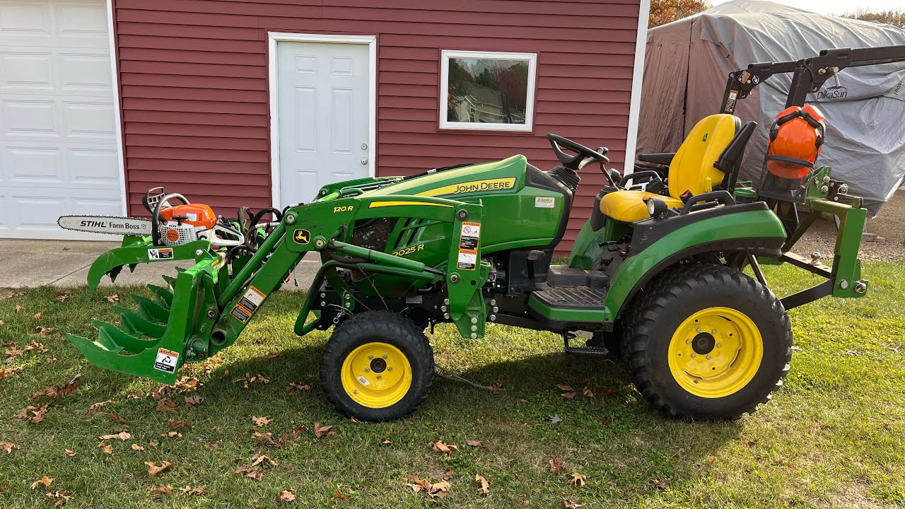John Deere 2025R. More grapple work, trees and stump removal. Still best attachment ever.