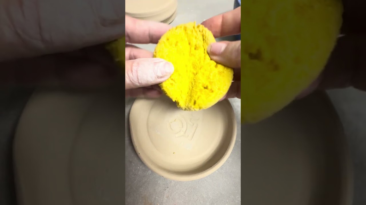 Water etching a tractor into handmade pottery