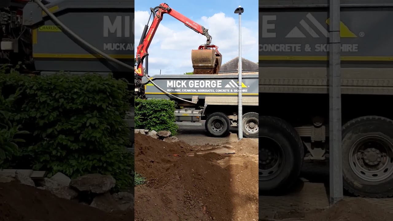 A grab lorry taking away a huge pile of earth and rubble dug out using a mini garden digger