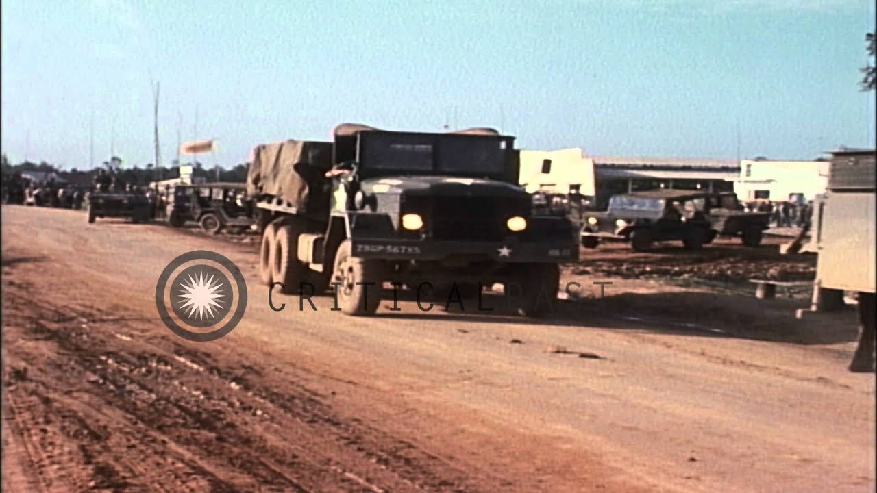 V-100 armored cars and M-151 armored jeeps pass through a village. HD Stock Footage