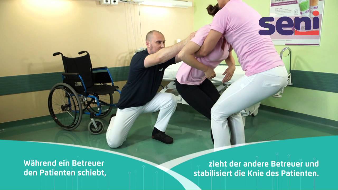 [DE] 07 Seni - Patiententransfer vom Boden in den Rollstuhl mit zwei Betreuern