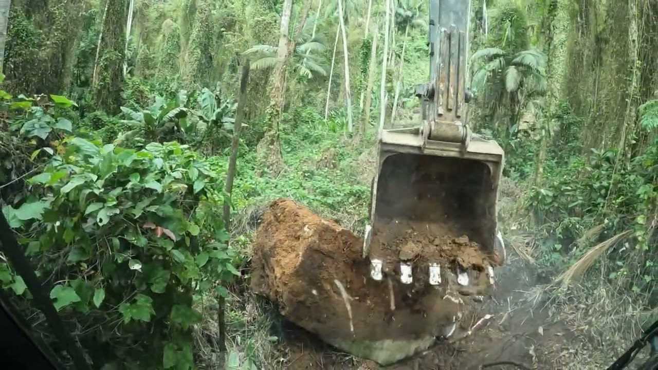 Escavadeira abrindo estradas com pedras enormes