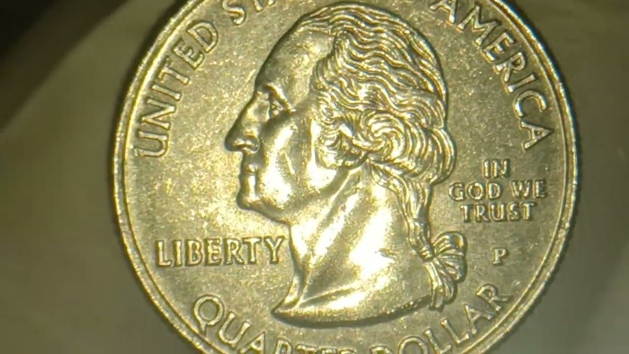 Монета США номиналом 25 центов, выпущенная в 2009 году на Гуаме, с необычным пузырьком на оборотн...