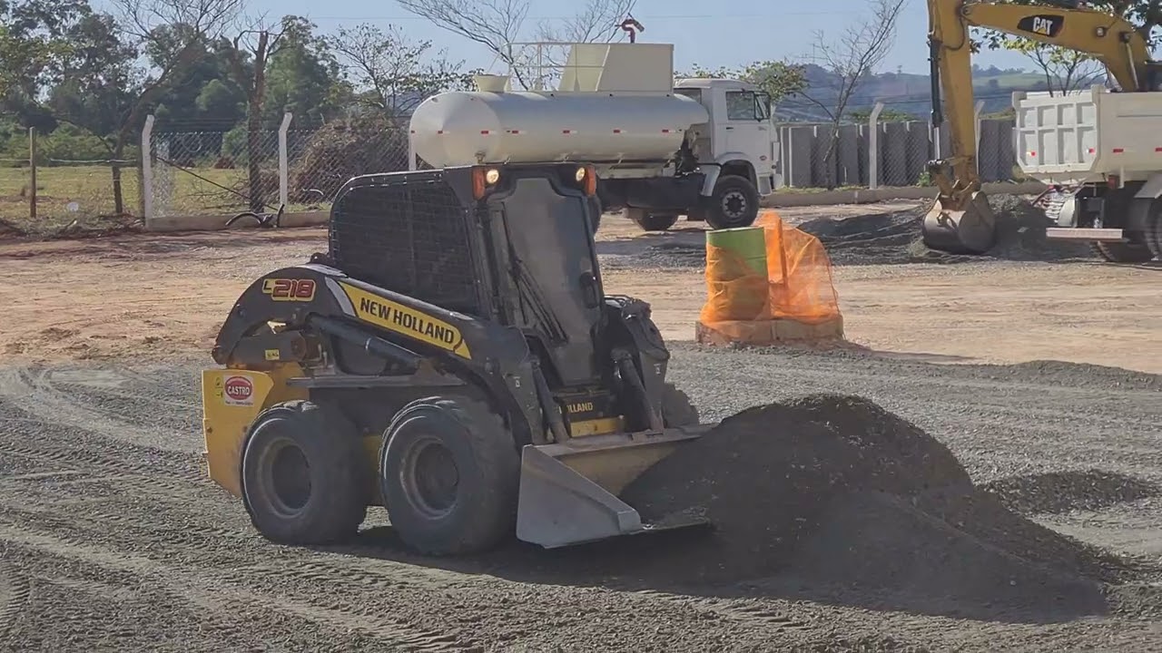 MINI CARREGADEIRA NEW HOLLAND L218 ESPALHANDO PÓ DE PEDRA (bobcat)