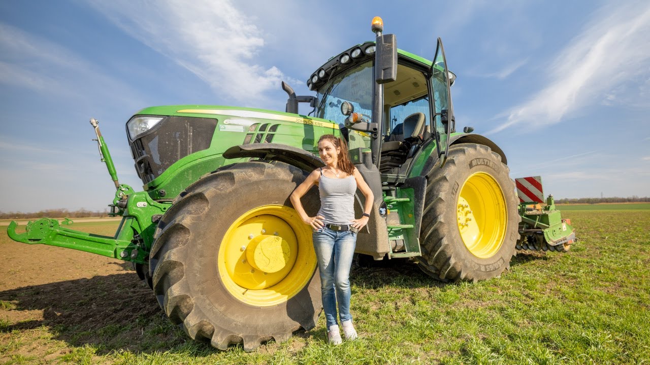 Farmer Girl cultivates field for the sunflowers with the john deere 6155R and the rotary cultivator