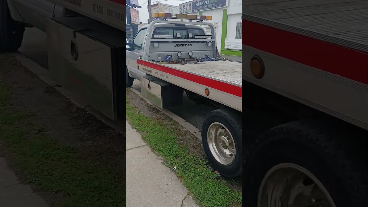 A GMC Sirrea stake body truck & a Ford Super Duty flatbed tow truck