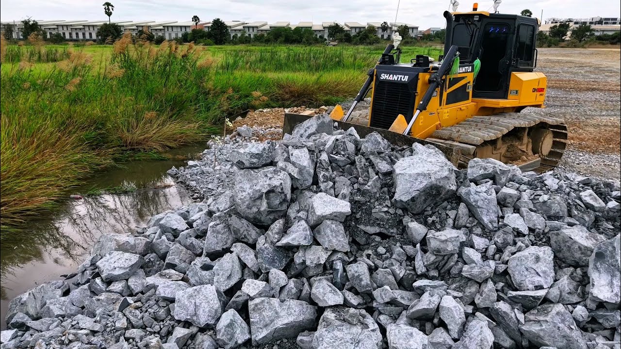 The full PowerFull of The DH17C3 Dozer Pushes Soil and Rock into the Deep Water With a Smoothly Push