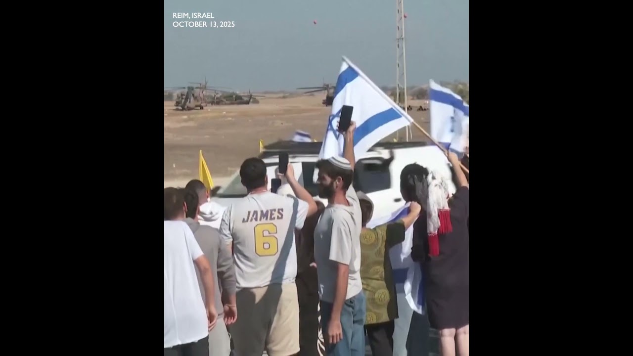 SCENE: Israelis cheer as convoy carrying released hostages drives past