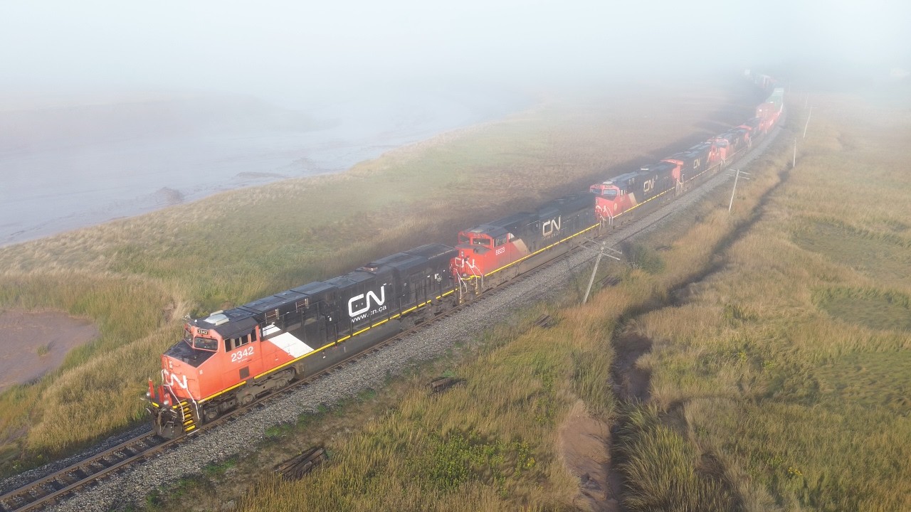 Aerial 4K View! Big Lashup on a Huge Stack Train CN 120 passing Upper Dorchester, NB at Track Speed
