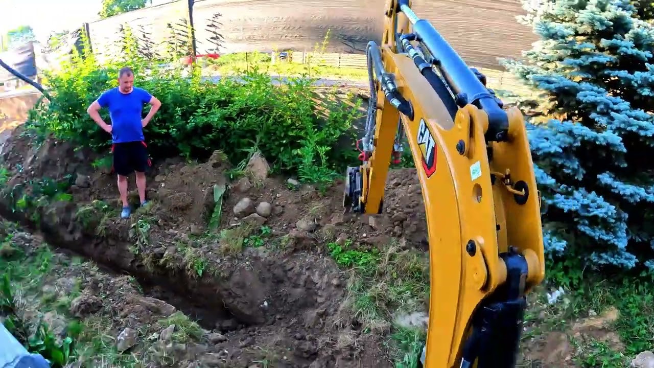 Výkop pre dažďovú kanalizáciu a trativod, vykopanie balvana.