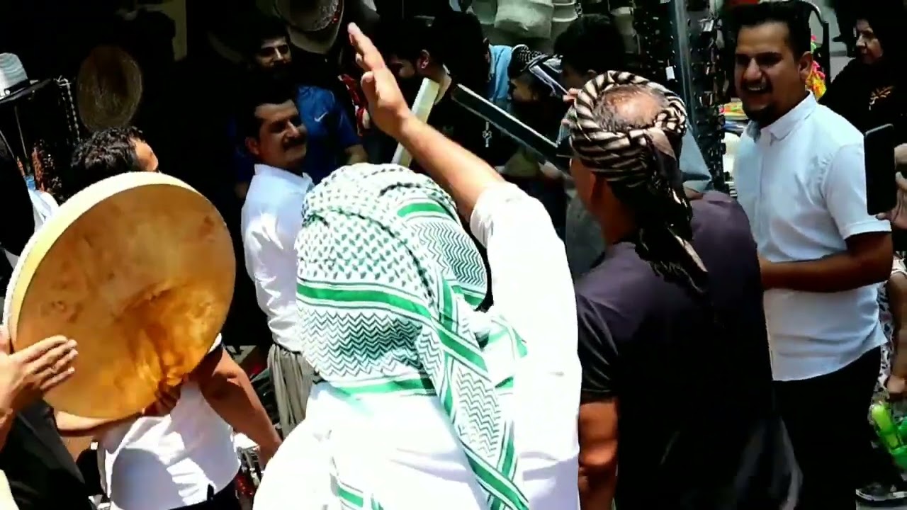 ژمارەیەک هاوڵاتی لەبەردەم خانەقای بیارە بەدەف وسرودی ئاینی سەرنجی گەشتیاران ڕادەکێشن.