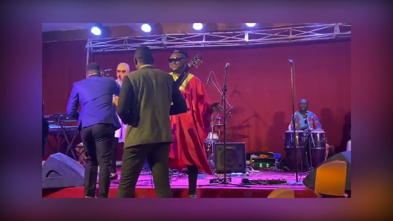 Hervé Nguebo playing guitar with one hand at a Concert