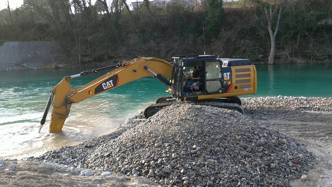 CATERPILLAR 326F LN moving gravel in Natisone river, Cividale del Friuli