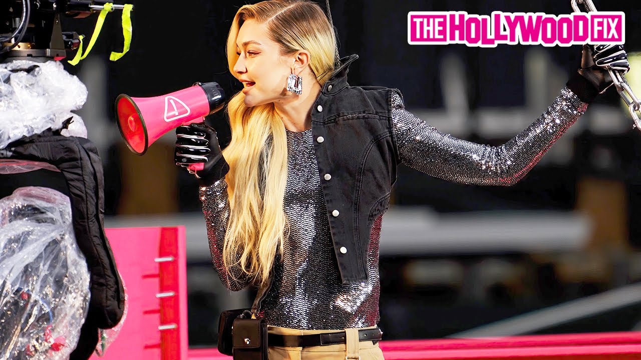 Gigi Hadid Hangs Off A Pink Steel Beam At A Construction Site For A Maybelline Commercial In N.Y.