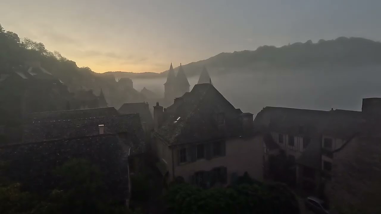 Church bells and morning fog, with view of Abbey Church of Sainte-Foy in Conques, France