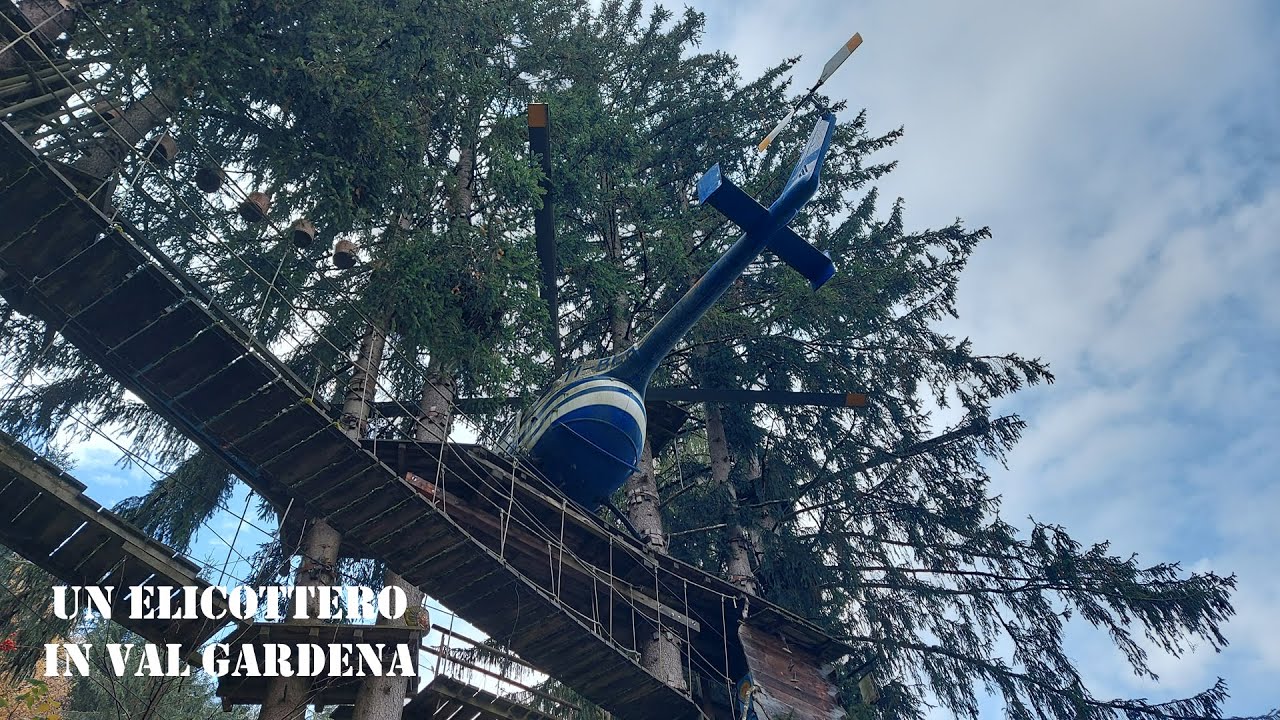 Un elicottero MBB BO105 a Ortisei tra i rami degli alberi