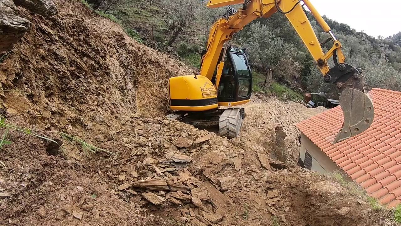 Excavator JCB JZ70 working at tight space with Benford dumper moving some dirt.