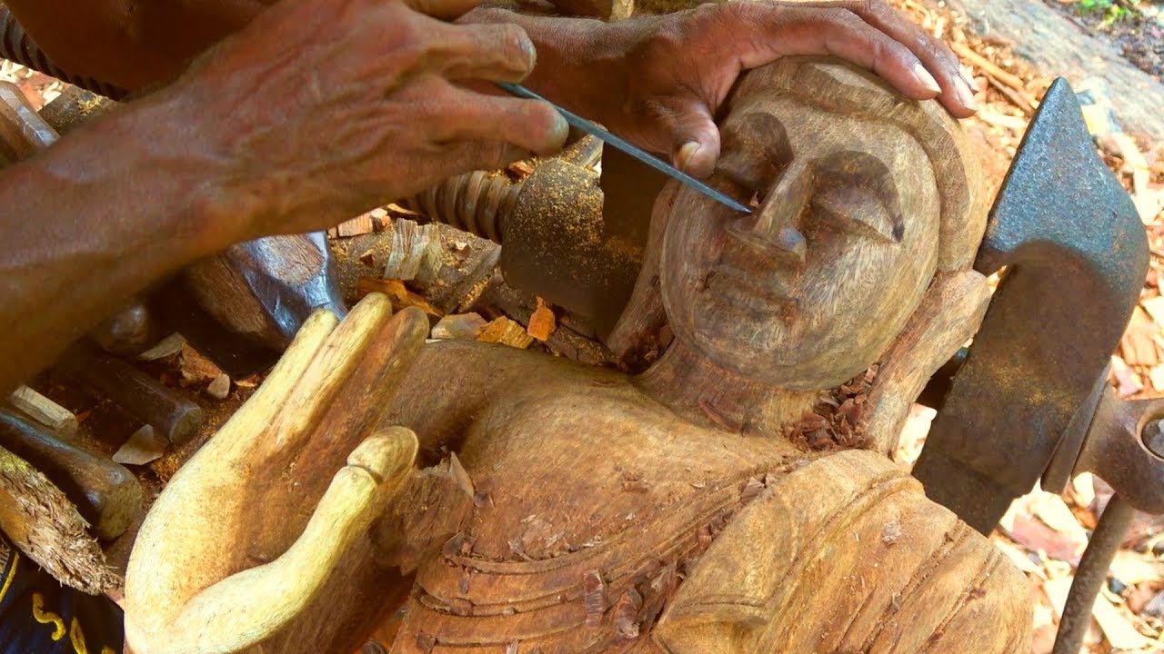 Wooden meditating Buddha statue intricately hand carved by traditional artisan