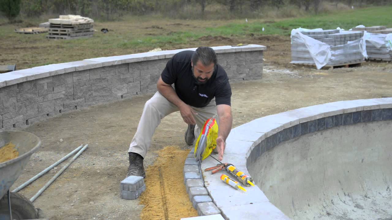 Laying pavers around pool coping