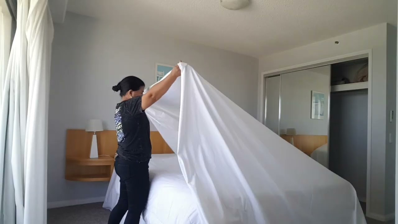 Back on duty housekeeping preparing bed for guest 