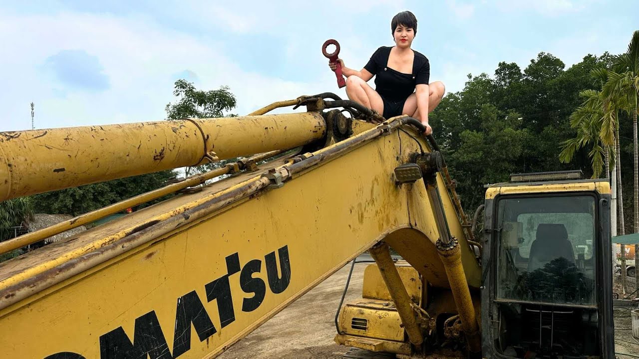 That's dangerous! But it's perfectly safe - the girl is climbing up to fix the excavator.