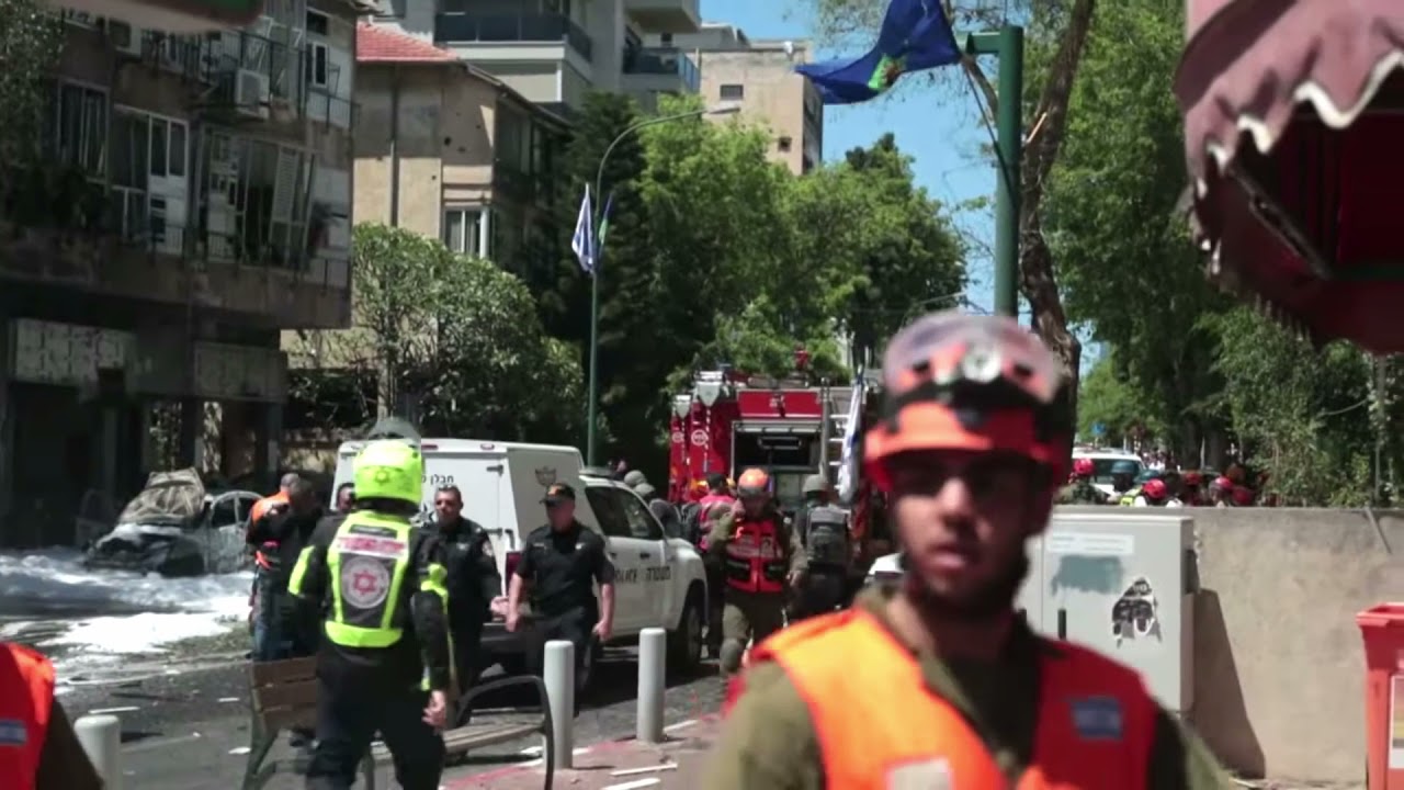 Israeli firefighters at the scene of a rocket explosion in Ramat Gan