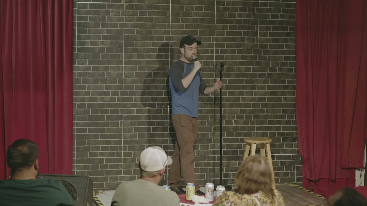 Jeremy Cash performs stand-up comedy in the basement of a church under his own power.
