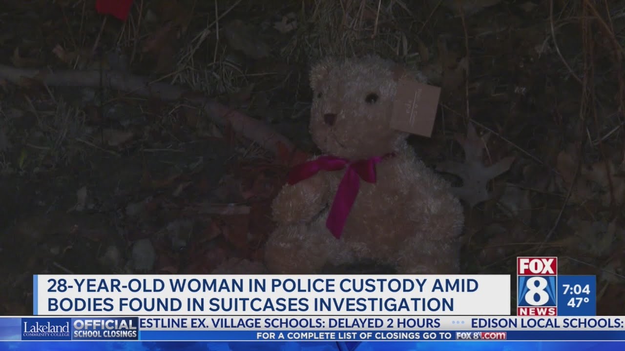 Woman detained after girls found buried in suitcases