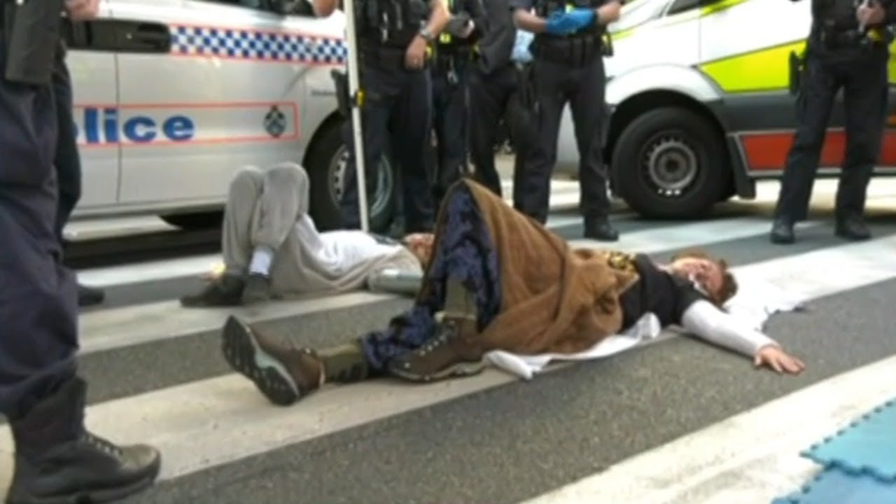 Climate change activists superglue themselves to Brisbane road