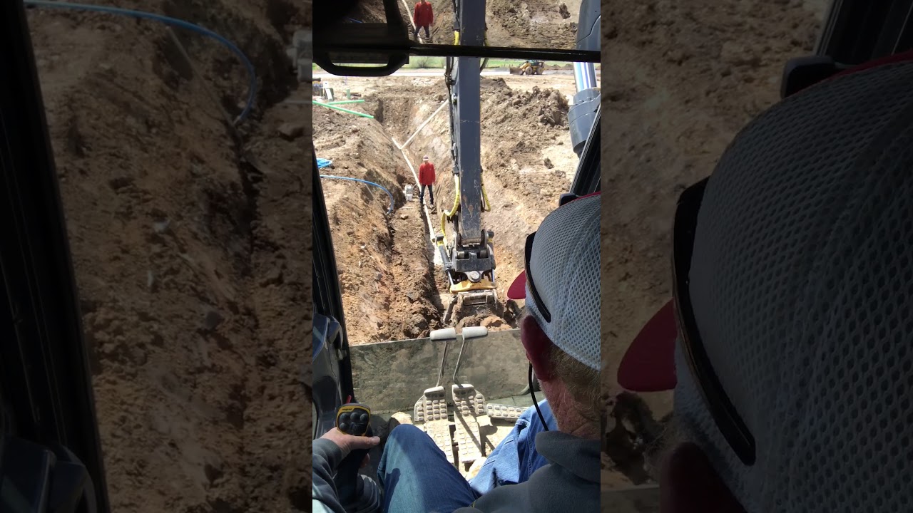 Engcon Tilt Rotator on a Deere 210G digging in Utilities