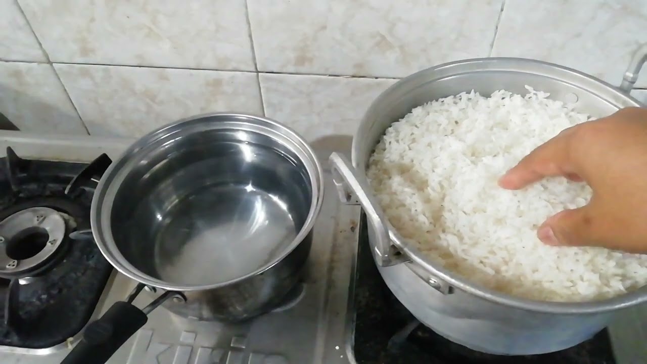 memasak nasi di dandang  kecil caranya di siram  dengan air mendidih  supaya cepat matang