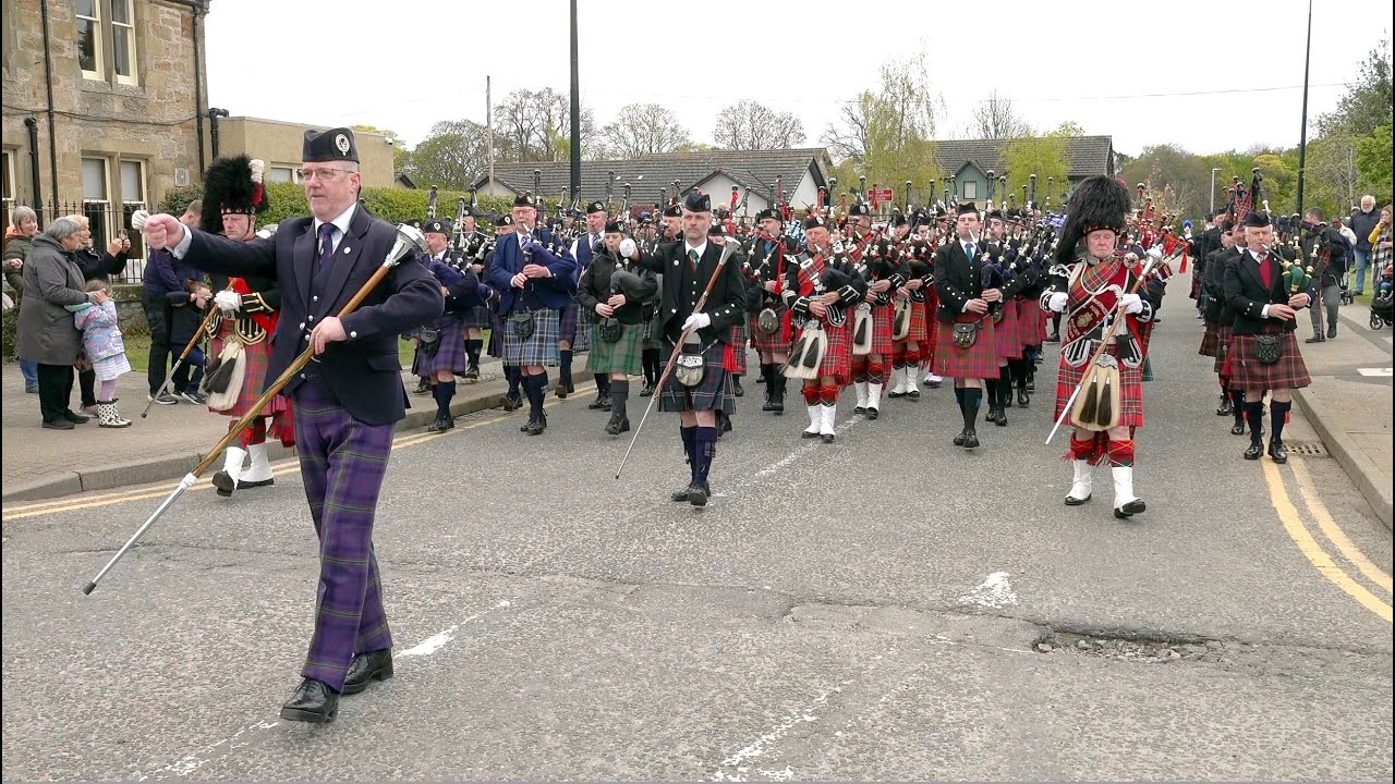 Drum Majors lead the Massed Pipe Bands through Alness town in the Scottish Highlands April 2023