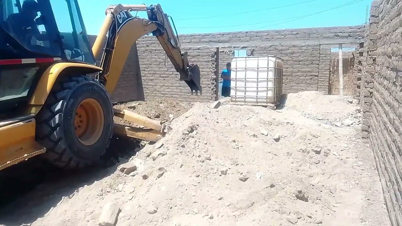 Haciendo limpieza para la continuación de una casa de adobe 