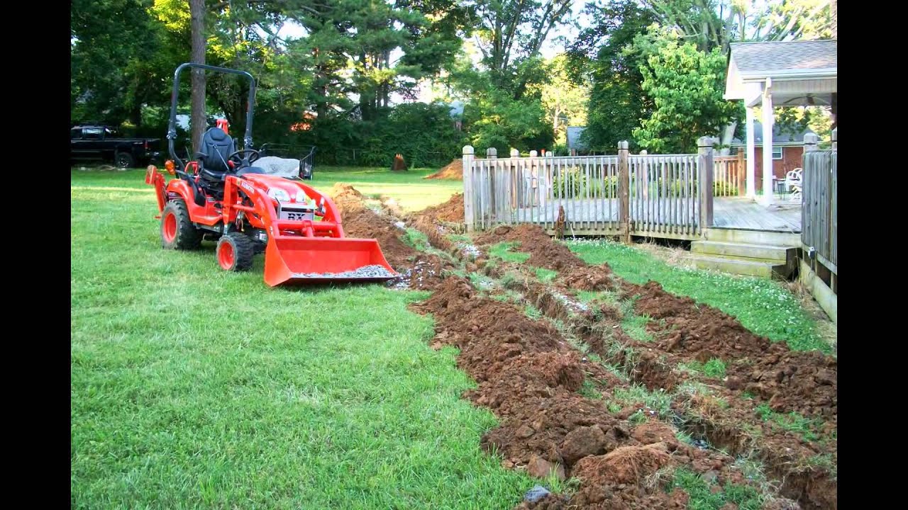 Kubota BX25D Tractor Loader Backhoe Digging a french drain
