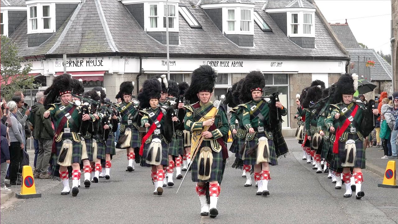 Huntly Pipe Band march through Aboyne at beginning of the 2022 Aboyne Highland Games in Scotland