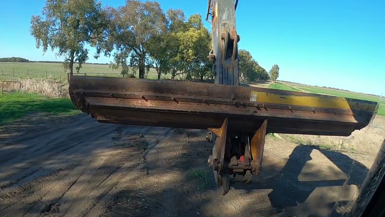 Excavator working 12ft blade cleaning drain