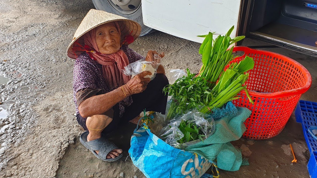 Cầm lòng không nổi khi thấy bà cụ ngồi bệt bên giỏ rau quê mời khách đi xe