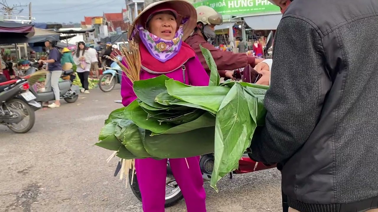 The woman selling leaf wraps for sticky rice cakes at the lively rural New Year market