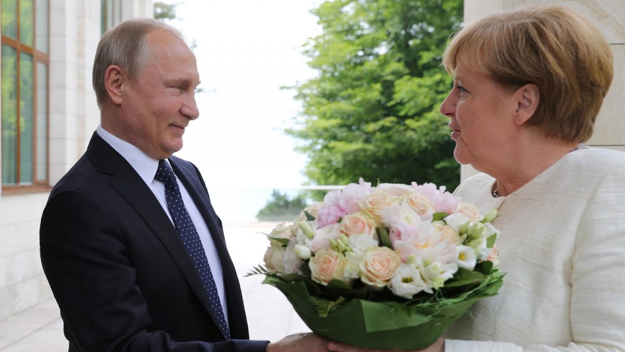 Vladimir Putin Greets Angela Merkel With A Bouquet Of Flowers