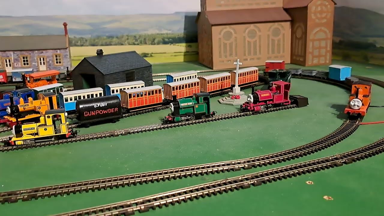 Bachmann Rheneas pulling 4 brown 3 grey slate wagons, blue box van and red brakvan 