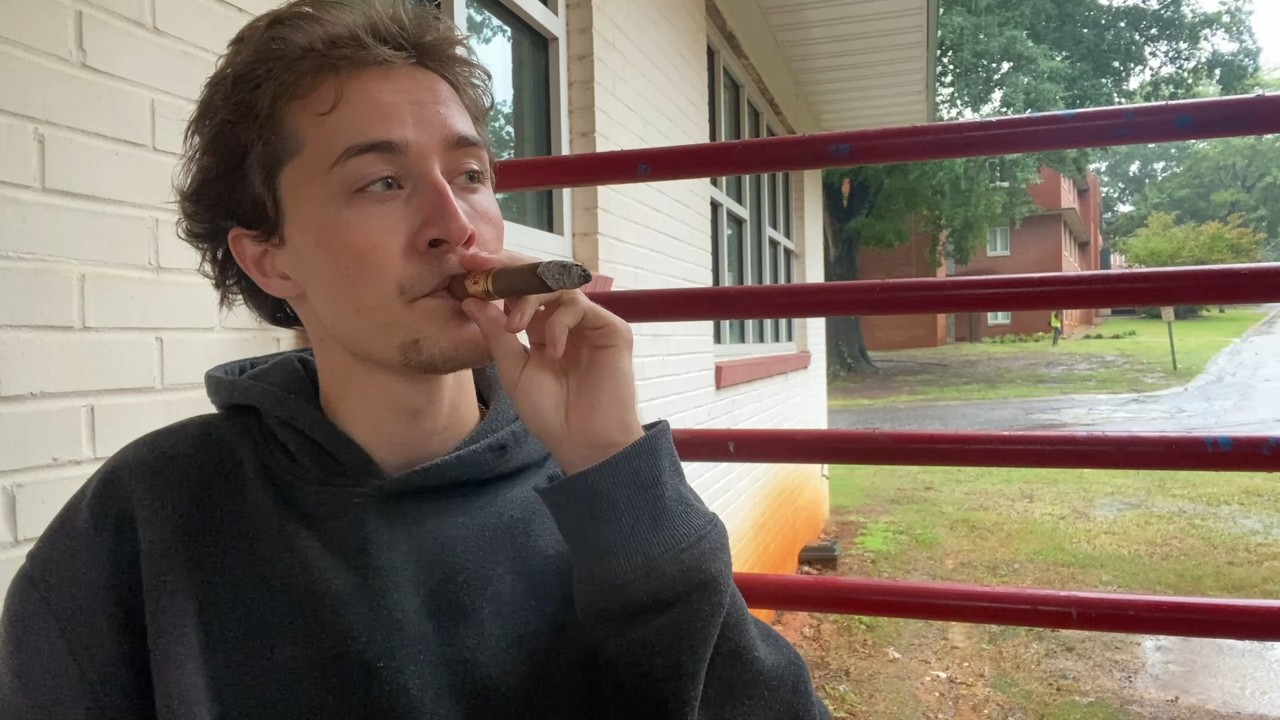 Smoking a Cigar Under a Metal Roof on a Rainy Day