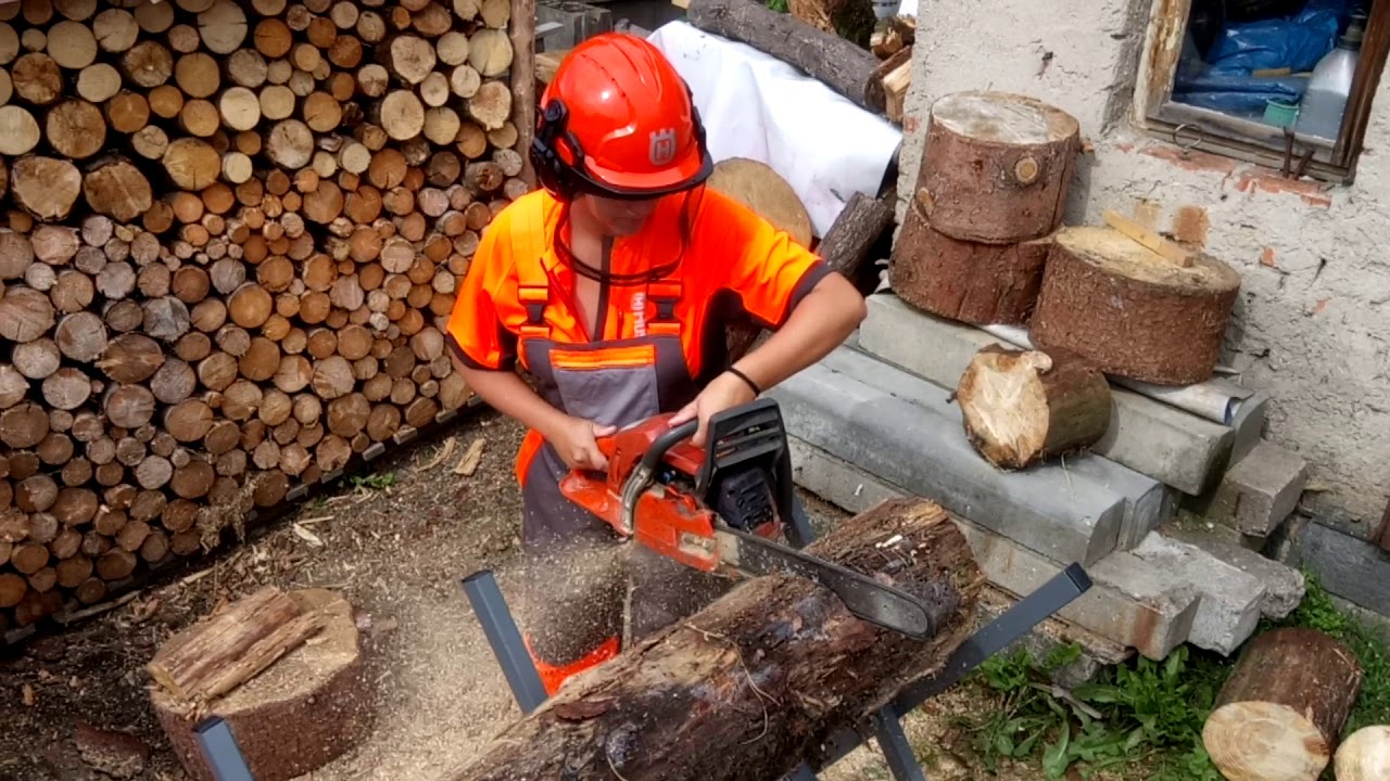 The woman cuts wood with Husqvarna 359 chain saw