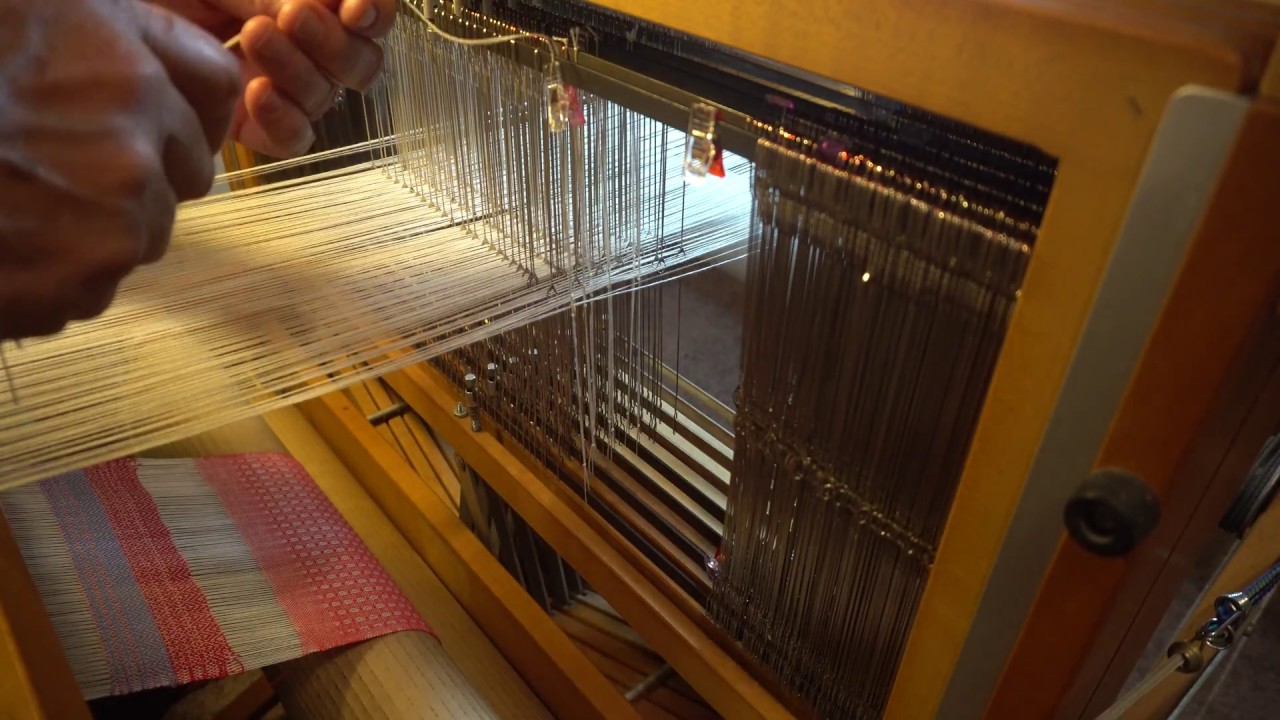tying up new headle on hand weaving loom