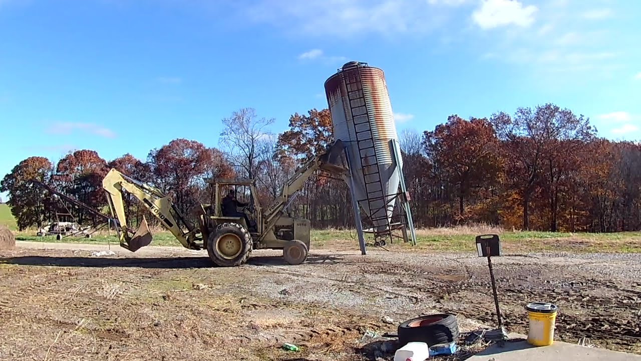 Moving feed bins with a Ford 555B backhoe