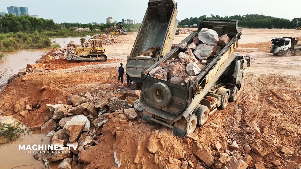 Huge Land Reclamation Process Dump Truck Management Unloading Rock Dirt Bulldozer Pushing Stone