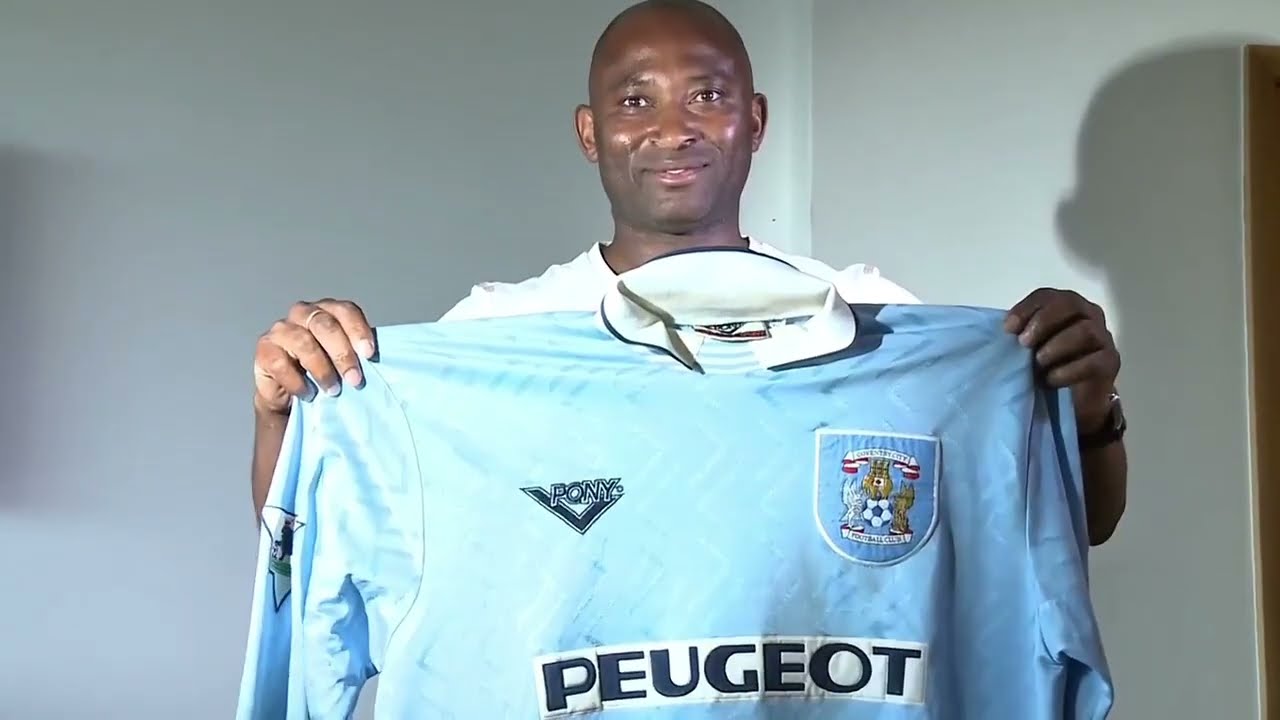 Legendary Peter Ndlovu Showing Off His Soccer Jerseys.