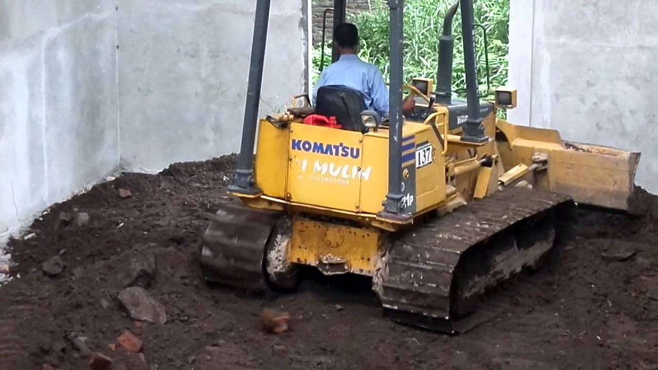 Mini Dozer Komatsu D21p Grading dirt in the small building
