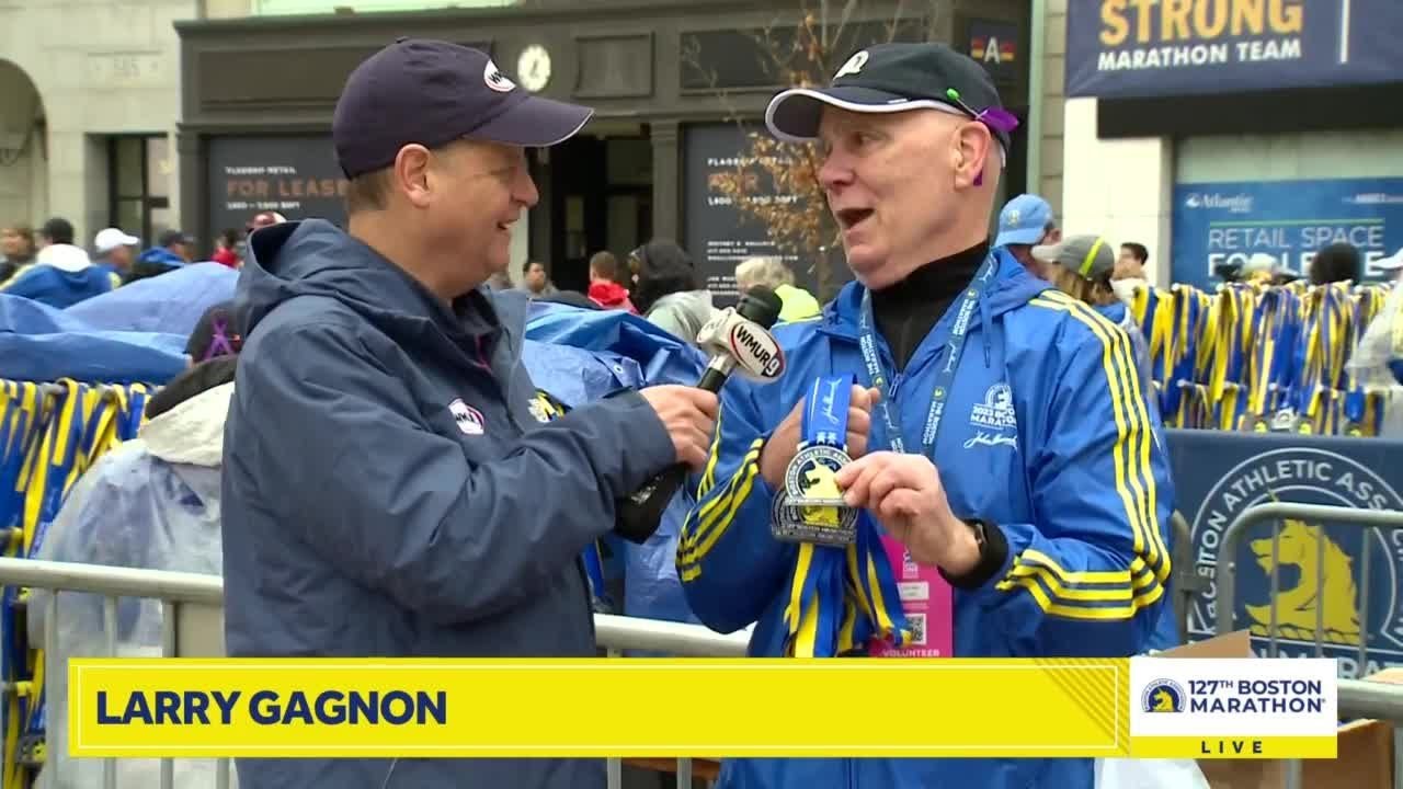 Electric atmosphere in Natick along Boston Marathon route; medals being distributed at finish line
