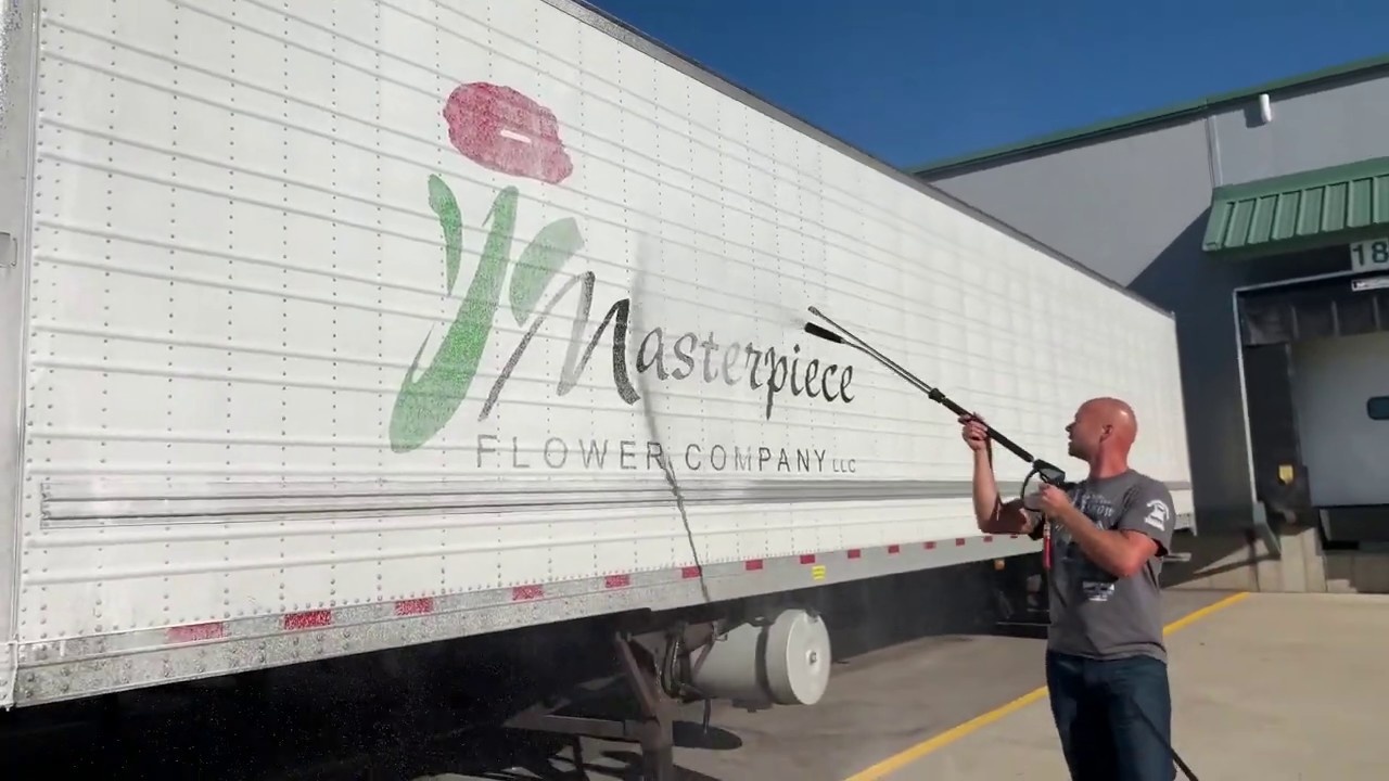 Fleet washer using foaminator gun to wash truck trailers