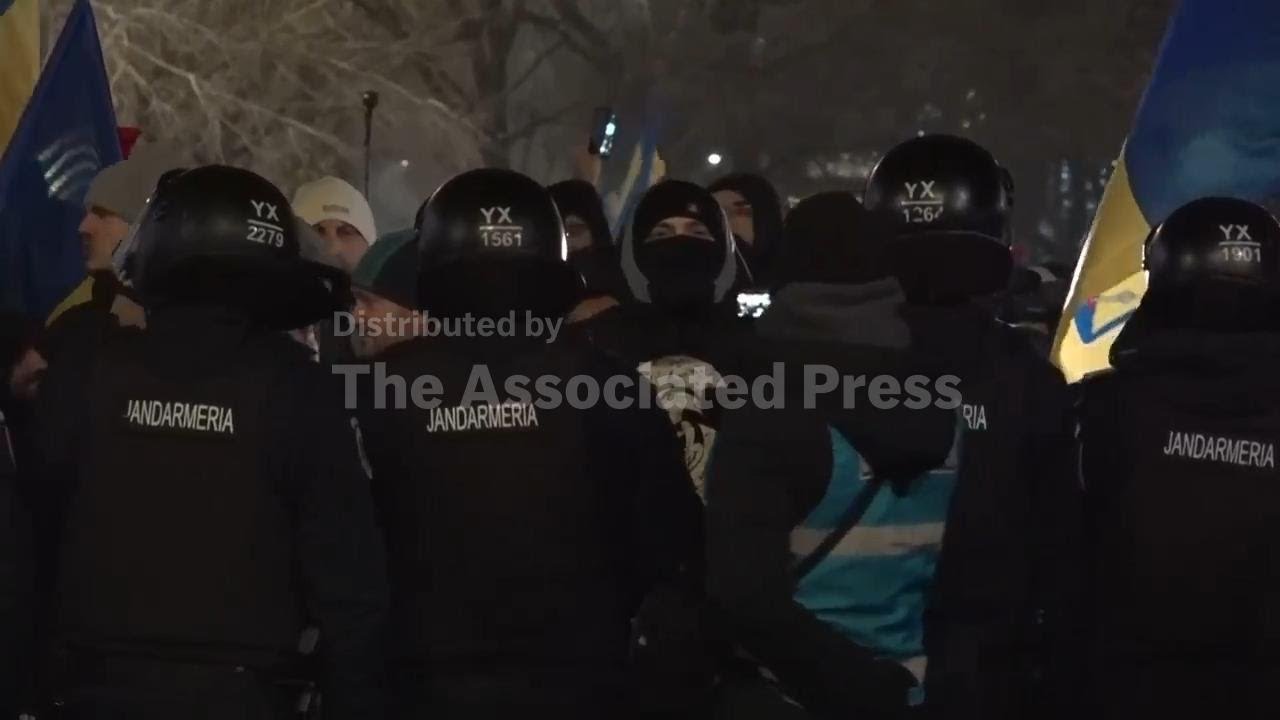Scuffles in front of central Bucharest government building between anti-austerity protesters and gen
